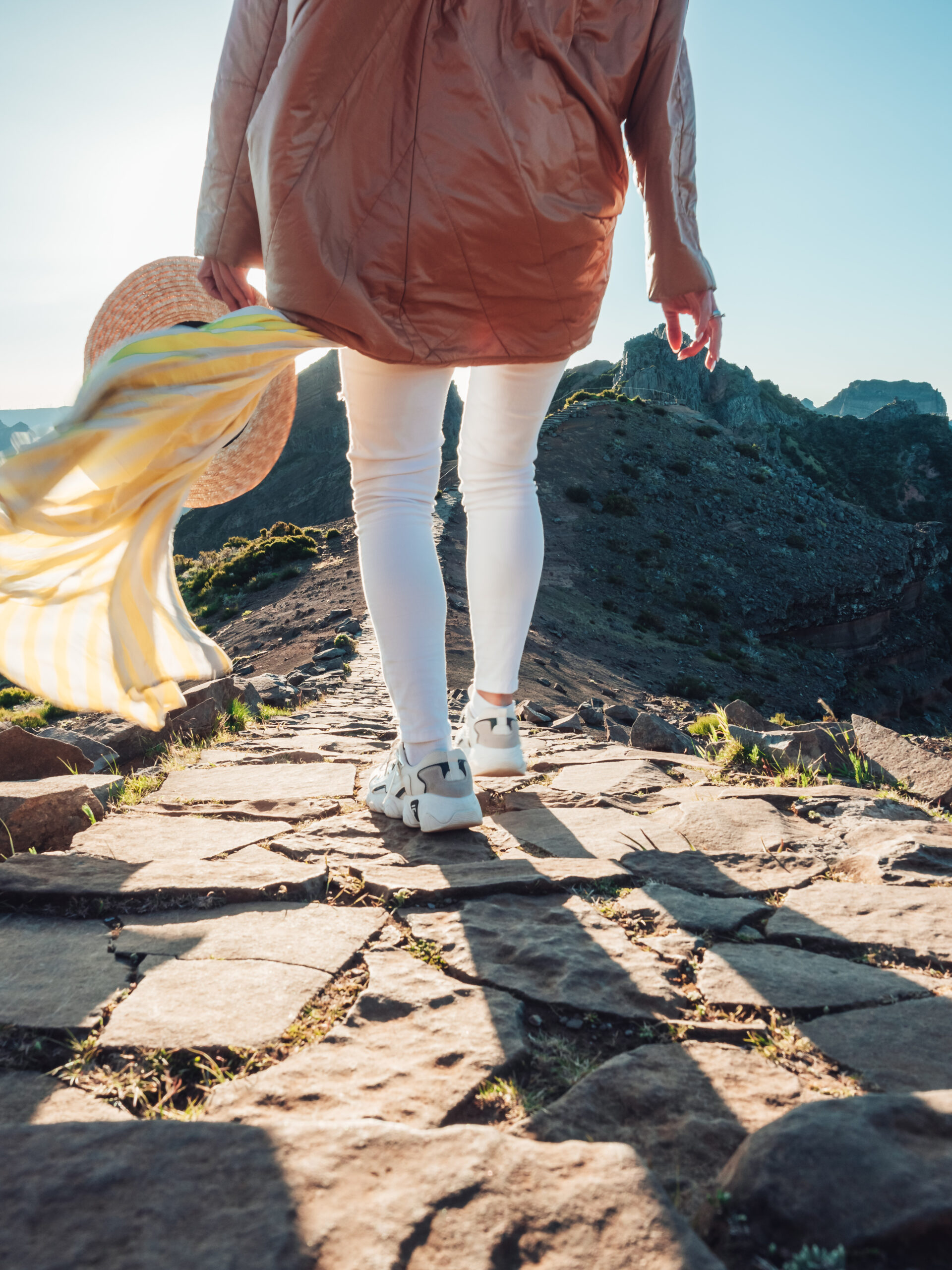 Person walking along a mountain path at sunrise symbolizing personal transformation, reinvention, and moving forward through uncertainty.